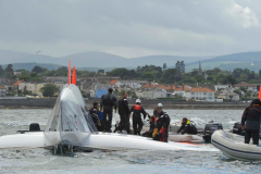Spindrift winner of the Lisbon to Dun Laoghaire leg crashes out of the La Route des Princes in Dublin bay in style as she capsizes ! members of the crew attend to the injured as reccue boats attend © Michael Chester